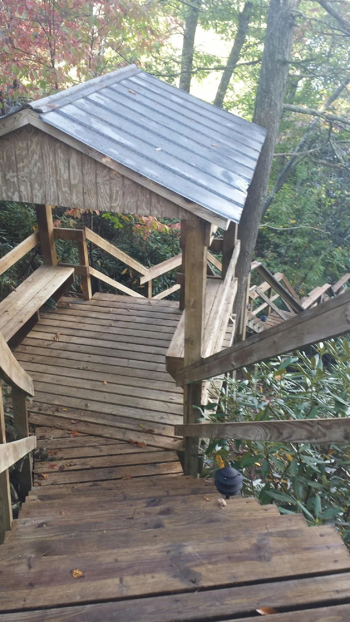 Metal roofed shelter over wooden steps on a wooded walkway — Skylight Repair & Installation work by our crew in Boardman