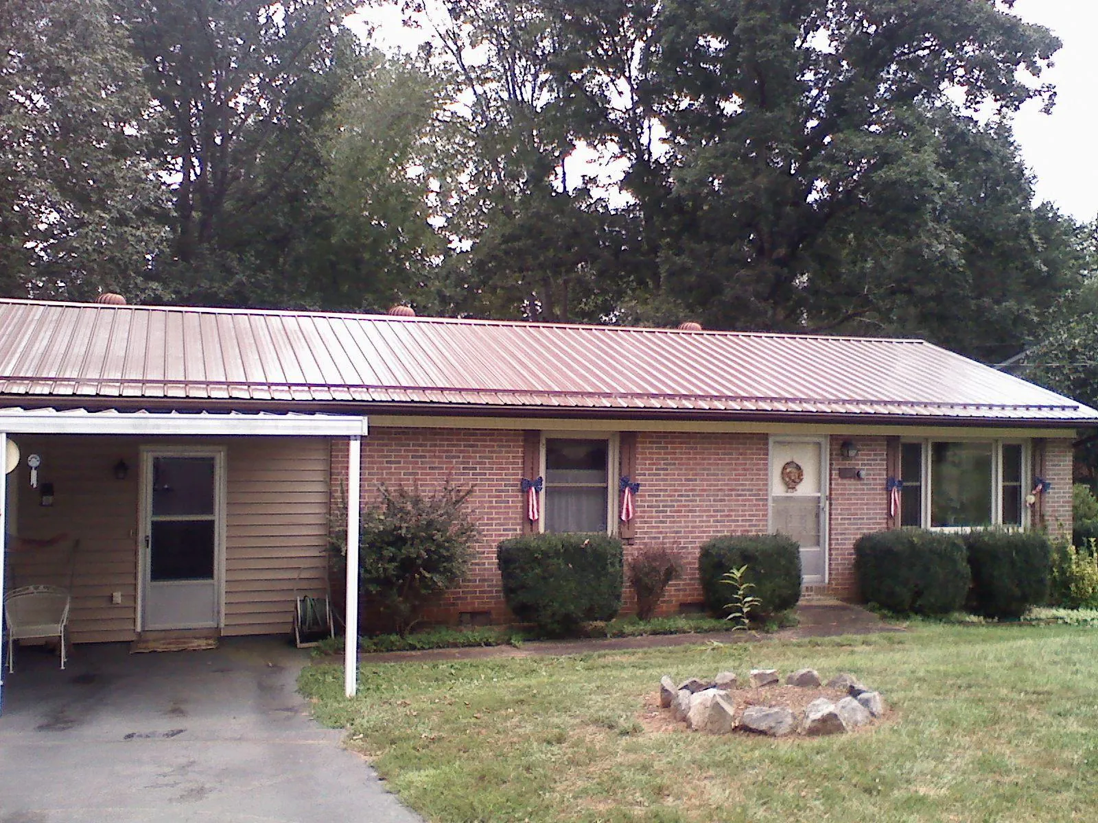 Bronze metal roof and carport on a brick ranch home — Roof Repair work by our crew in Boardman